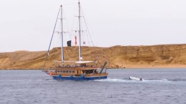 Kayalar arka planda Fırtınalı Denizi'nde Güzel Turistik Yat Yelkenler. Mısır