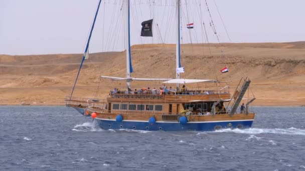 Beautiful Tourist Yacht Sails in the Stormy Sea on the background of Rocks. Egypt — Stock Video