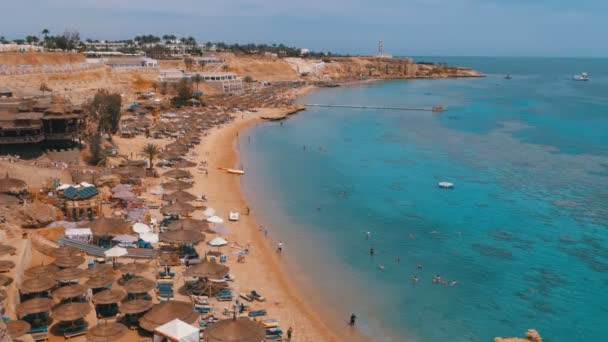 ชายหาดที่มีร่มและเตียงอาบแดดที่โรงแรมหรูบนทะเลแดงใกล้กับแนวปะการัง อียิปต์ . — วีดีโอสต็อก