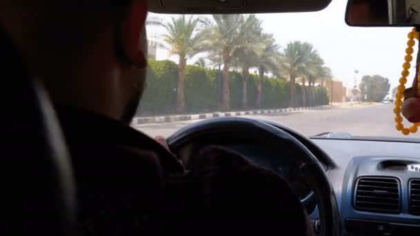 Вид со спины таксиста в Египте, который ездит по курортному городу днем — стоковое видео