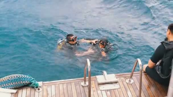 Подводное плавание. Турист с инструктором в Красном море готовятся к погружению — стоковое видео