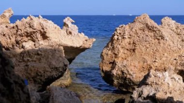 Mercan Resifi yakınlarındaki Cliff ile Kızıldeniz'deki Rocky Plajı. Mısır. Kızıldeniz Kıyısında tatil köyü.