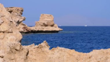 Mercan Resifi yakınlarındaki Cliff ile Kızıldeniz'deki Rocky Plajı. Mısır. Kızıldeniz Kıyısında tatil köyü.
