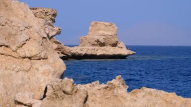 Mercan Resifi yakınlarındaki Cliff ile Kızıldeniz'deki Rocky Plajı. Mısır. Kızıldeniz Kıyısında tatil köyü.