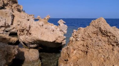 Mercan Resifi yakınlarındaki Cliff ile Kızıldeniz'deki Rocky Plajı. Mısır. Kızıldeniz Kıyısında tatil köyü.