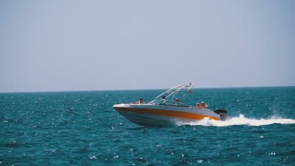 Barco a motor con la gente navega a lo largo de las olas en el mar rojo. Moción lenta — Vídeo de stock