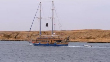 Kayalar arka planda Fırtınalı Denizi'nde Güzel Turistik Yat Yelkenler. Mısır