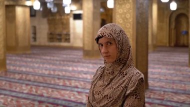 Rahibe cübbesi giymiş bir kadın İslami bir tapınağın içinde duruyor. Mısır