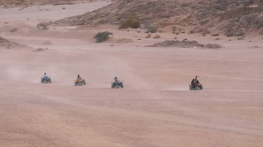 Dağların arka planında Mısır'da Çöl üzerinden bir Quad Bike Rides Sütun. Sürüş Avs.