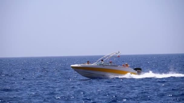 Imbarcazione a motore con persone naviga lungo le onde nel mare rosso. Rallentatore — Video Stock