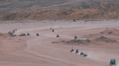 Dağların arka planında Mısır'da Çöl üzerinden Quad Bike Rides Grubu. Sürüş Avs.