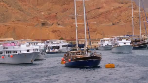 Molo ze statkami i jachtami na tle gór na pustyni egipskiej. — Wideo stockowe