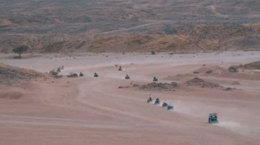 Dağların arka planında Mısır'da Çöl üzerinden bir Quad Bike Rides Sütun. Sürüş Avs.