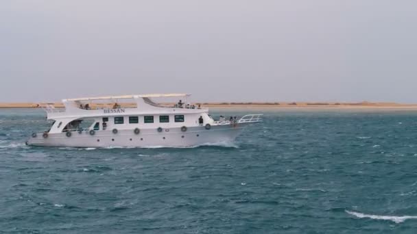 Човен насолоди з туристами вітрилами в бурхливому морі на тлі гірських порід. Єгипет — стокове відео