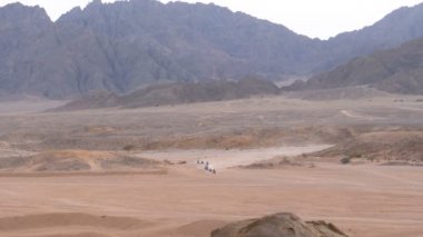 Dağların arka planında Mısır'da Çöl üzerinden Quad Bike Rides Grubu. Sürüş Avs.