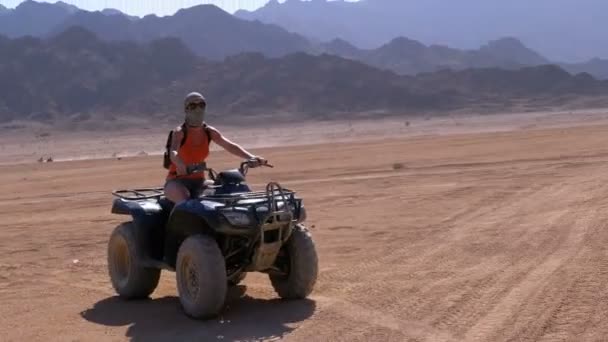 산의 배경에 이집트의 사막을 통해 쿼드 자전거에 섹시한 소녀 — 비디오