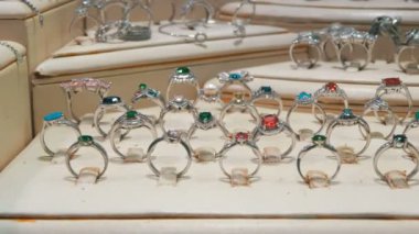 Mağaza vitrininde gümüşten yapılmış değerli taşlar ve takılar ile çeşitli gümüş yüzükler.