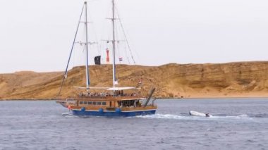 Turistler ile Güzel Ahşap Yat Kayalar arka planda Fırtınalı Denizi'nde Yelken olduğunu. Mısır