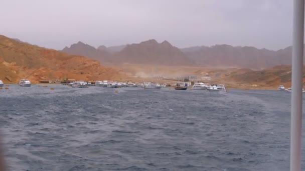 Muelle con barcos y yates en el fondo de las montañas en el desierto de Egipto . — Vídeos de Stock