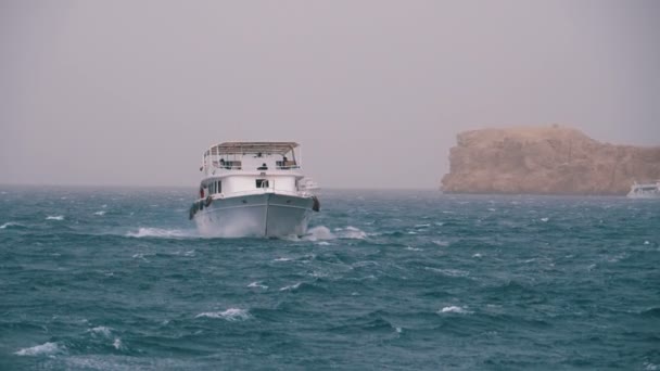 Pleasure Boat with Tourists is Sailing in the Storm Sea on background of Rocks. Egypt — Stock Video