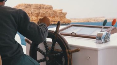 Kaptan Kayalar yakınındaki Deniz Fırtınası'nda Turist Yatı Kontrol Eder. Bir zevk tekne direksiyonu.
