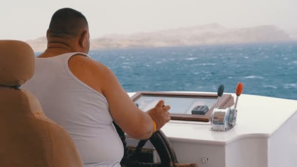 Толстый капитан контролирует туристическую яхту в Морской Буре. Рулевое колесо судна удовольствия . — стоковое видео
