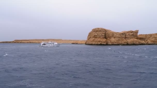바위의 배경에 폭풍우 바다에서 관광객 항해와 유람선. 이집트 — 비디오