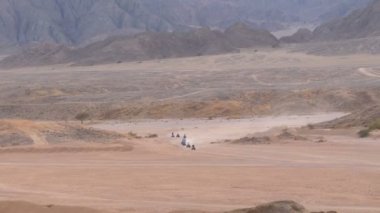 Dağların arka planında Mısır'da Çöl üzerinden Quad Bike Rides Grubu. Sürüş Avs.