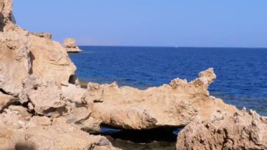 Mercan Resifi yakınlarındaki Cliff ile Kızıldeniz'deki Rocky Plajı. Mısır. Kızıldeniz Kıyısında tatil köyü.