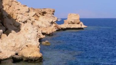 Mercan Resifi yakınlarındaki Cliff ile Kızıldeniz'deki Rocky Plajı. Mısır. Kızıldeniz Kıyısında tatil köyü.