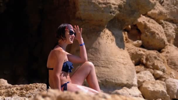 Sexy chica sentada en el acantilado en la playa rocosa de Egipto por el Mar Rojo — Vídeos de Stock