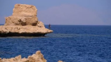 Mercan Resifi yakınlarındaki Cliff ile Kızıldeniz'deki Rocky Plajı. Mısır. Kızıldeniz Kıyısında tatil köyü.