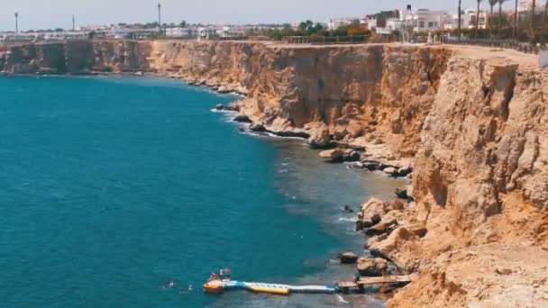 Rocky Beach en Egipto. Playa en una bahía en la costa con olas en el Mar Rojo y arrecifes de coral . — Vídeos de Stock