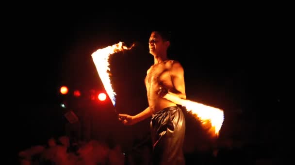 무대에서 화재 쇼 성능. 야간 쇼에서 불타는 팬들과 함께 춤을 추는 청년. 슬로우 모션 — 비디오