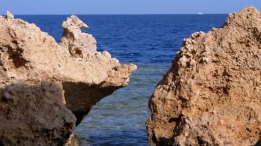 Mercan Resifi yakınlarındaki Cliff ile Kızıldeniz'deki Rocky Plajı. Mısır. Kızıldeniz Kıyısında tatil köyü.