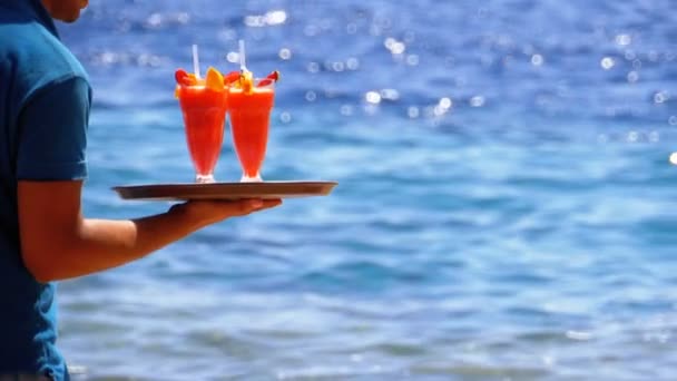 Camarero sirviendo bebidas en la playa, Egipto. Camarero sosteniendo una bandeja con jugos tropicales — Vídeo de stock