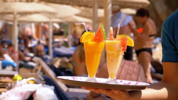 Exotische cocktails in een glas met een rietje op een dienblad op de achtergrond van de zee. Egypte. — Stockvideo