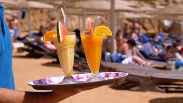 Exotische cocktails in een glas met een rietje op een dienblad op de achtergrond van de zee. Egypte. — Stockvideo