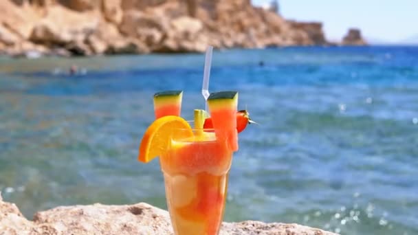 Exotische cocktail in glas staat op het rif strand op de achtergrond van de rode zee. Egypte. — Stockvideo