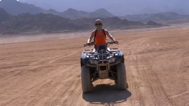 Szexi lány egy quad bike túrák a sivatagban Egyiptom a háttérben a hegyek. Lassított mozgás