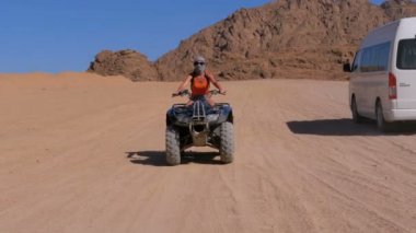 Dört bisiklet üzerinde kız dağlar arka planda Mısır çöl üzerinden rides. Yavaş hareket