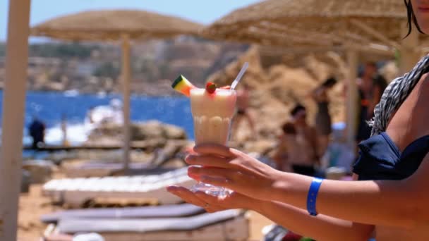 Дівчина з коктейлем в руках на пляжі Єгипту, Червоне море. Повільний рух — стокове відео