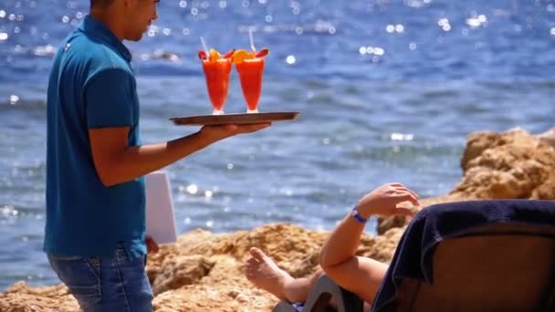 エジプトのビーチで飲み物を提供するウェイター。熱帯ジュースでトレイを持つウェイター — ストック動画