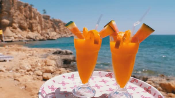 Exotische cocktails in een glas met een rietje op een dienblad op de achtergrond van de zee. Egypte. — Stockvideo