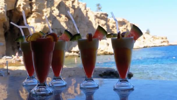 Különböző friss egzotikus koktélok vagy gyümölcslevek az üveg szalma a Beach Bar. Egyiptom, Red Sea. — Stock videók