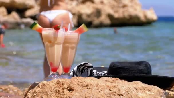 Succo di frutta fresca tropicale, cappello e bicchieri sulla spiaggia d'Egitto sta su una roccia vicino al Mar Rosso — Video Stock