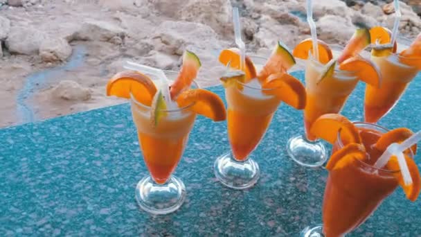 Різноманітні свіжі екзотичні коктейлі або соки у склі з соломою на пляжному барі. Єгипет, Червоне море. — стокове відео