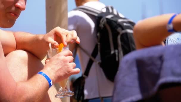 Człowiek na plaży picie egzotycznego koktajlu przeciw morzu. Zwolnionym — Wideo stockowe