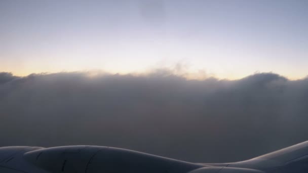 Pohled z okna podokna pro cestující letící v oblacích při západu slunce v noci. — Stock video