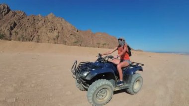 Seksi Kadın Mısır Çölü'nde bir Dört Bisiklet Sürme olduğunu. Hareket halindedinamik görünüm.